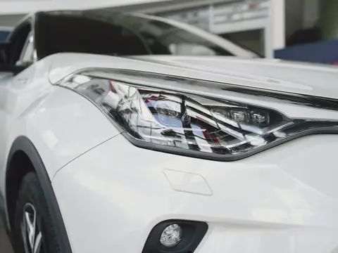 The front bumper and headlight of a modern white car